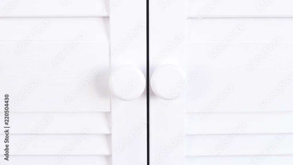 Hand closed white wood door with black background. Hand closed white wood door with black background.