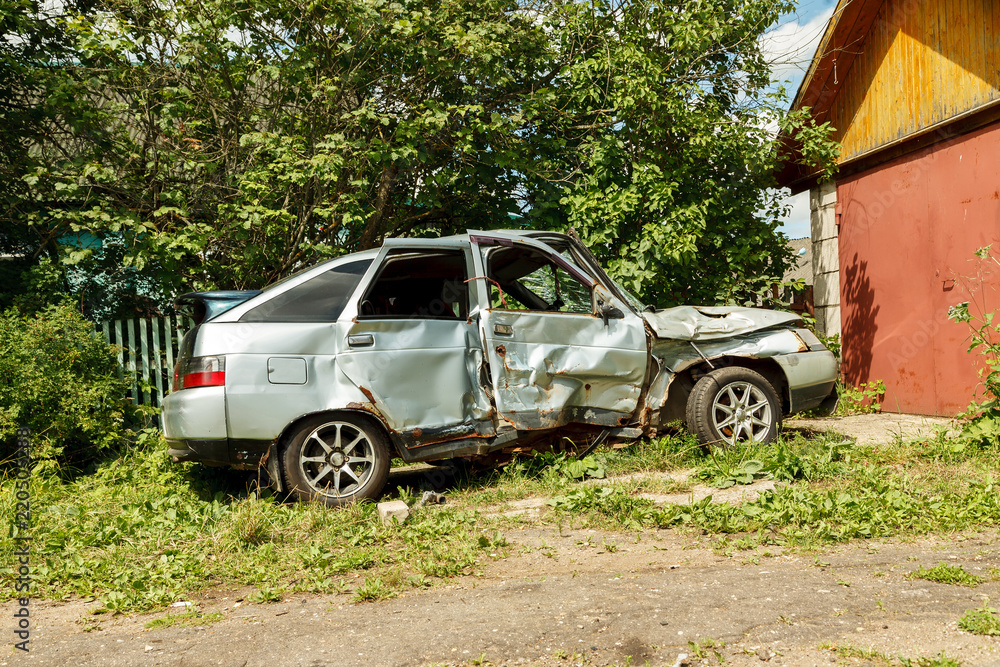 Damaged car after accident near garage in the yard Damaged car after accident near garage in the yard