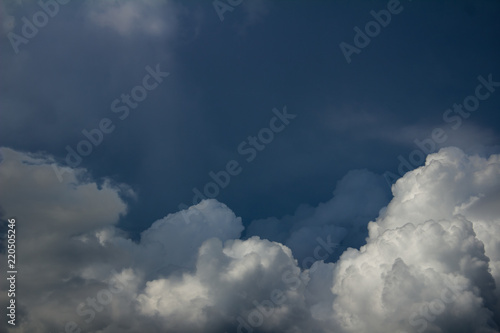 white blurred cumulus clouds on dark blue sky before the storm © nucia