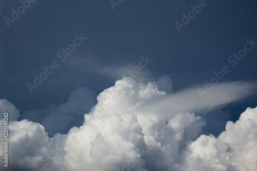 white cumulus bluring clouds on dark blue sky before the storm photo