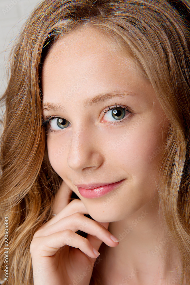 Portrait of a brown-haired woman with long wavy hair and clean skin. Portrait of a brown-haired woman with long wavy hair and clean skin.