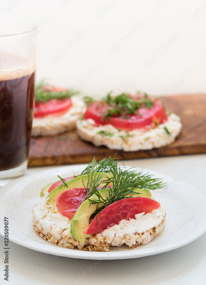 Crisp breads with cheese, tomatoes, avocado and coffee