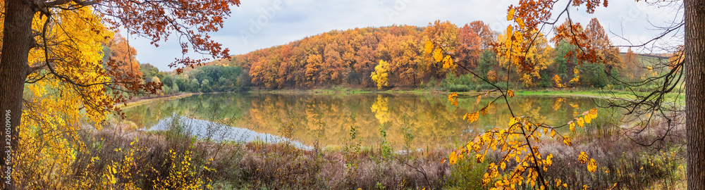 Autumn landscape - the forest by lake in the sunny autumn day, panorama, banner Autumn landscape - the forest by lake in the sunny autumn day, panorama, banner
