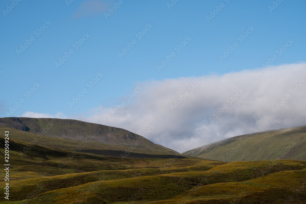 View of hills in Scottish Highlands on a clear summer's day, with low lying cloud. Photographed early in the morning near Inverness