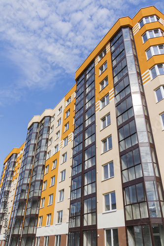 Modern apartment building in sunny day against blue sky.