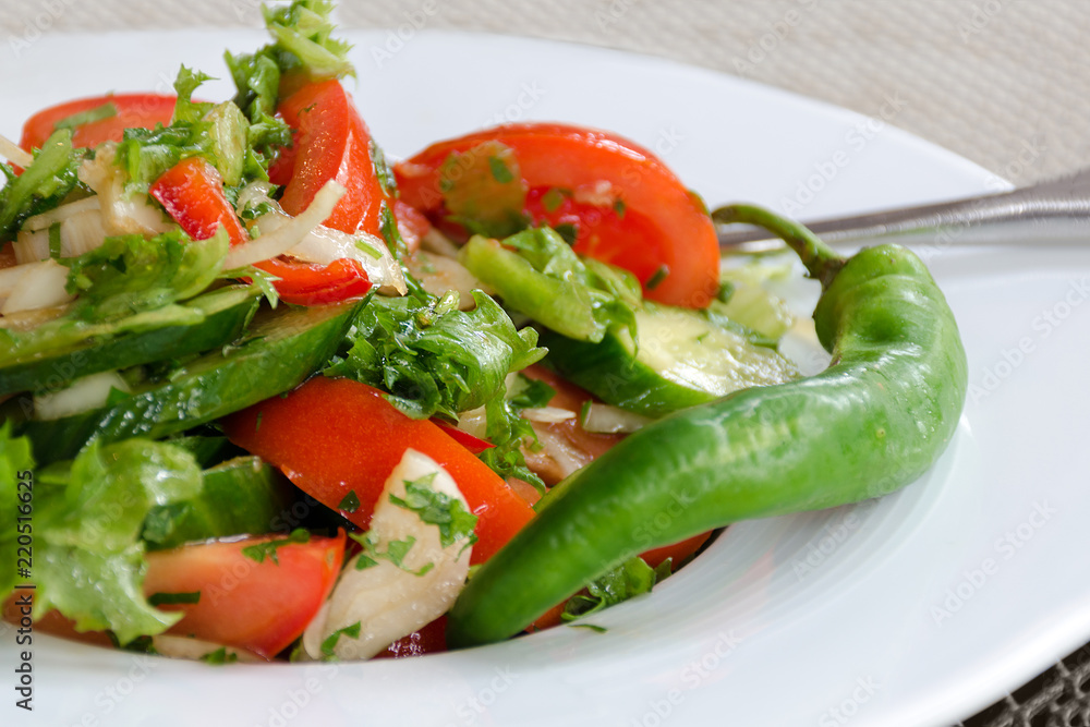 Healthy natural food, fresh salad with vegetables in plate - cucumbers, tomato, greens, close up. Shallow depth of field. Concept of vegetarianism, low calorie diet, weight loss, proper nutrition Healthy natural food, fresh salad with vegetables in plate - cucumbers, tomato, greens, close up. Shallow depth of field. Concept of vegetarianism, low calorie diet, weight loss, proper nutrition