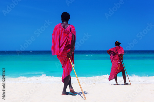 Two maasai warriors looking on ocean.
