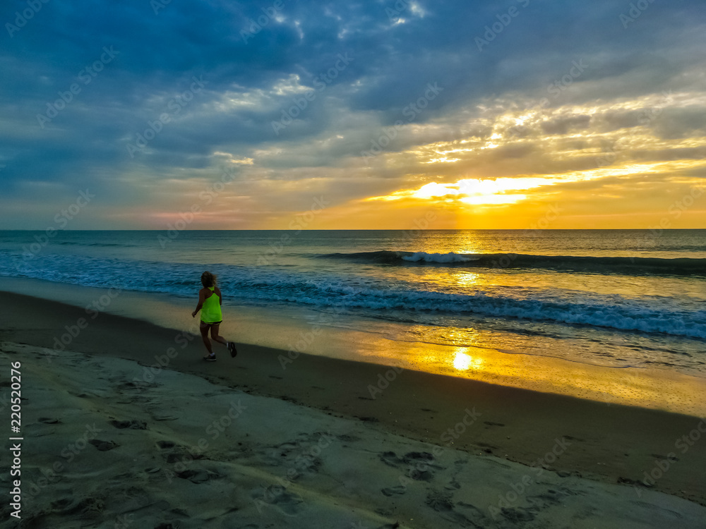 Woman running on the beach at sunset. Florida, USA