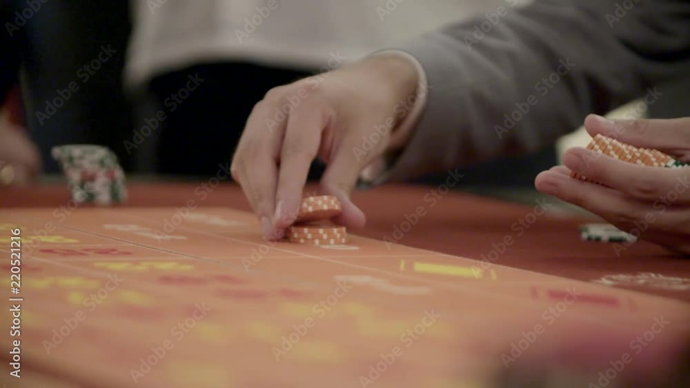Hands of unidentified people playing poker in the casino, roulette in slow motion. Gambling, addiction concept. Hands of unidentified people playing poker in the casino, roulette in slow motion. Gambling, addiction concept.