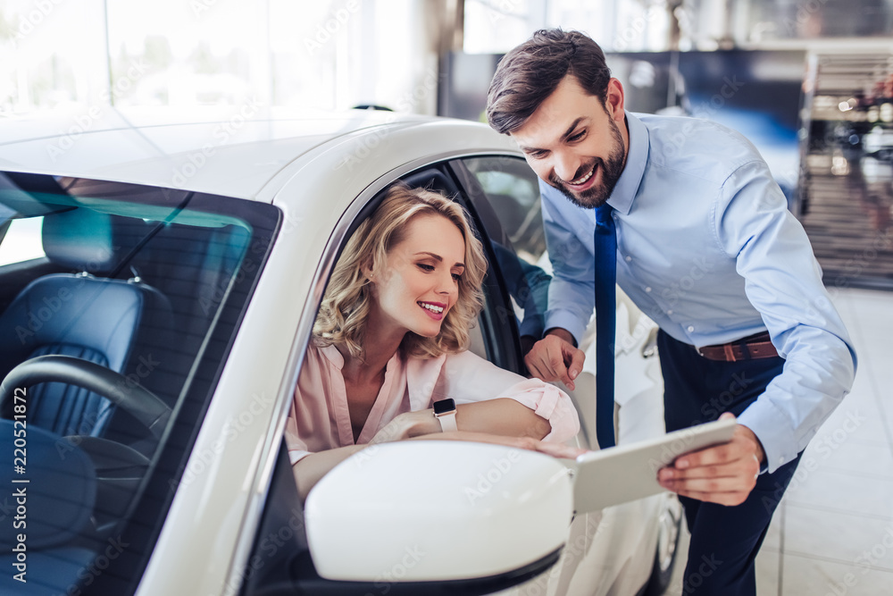 Fototapeta premium salesman talking with client sitting in the car
