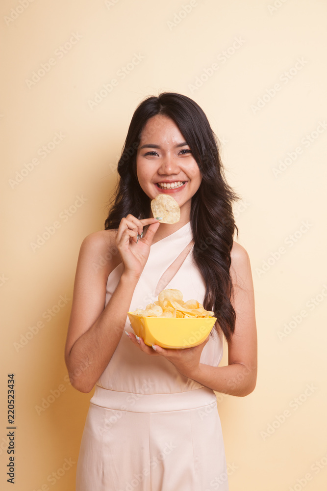 Young Asian woman eat potato chips. Young Asian woman eat potato chips.