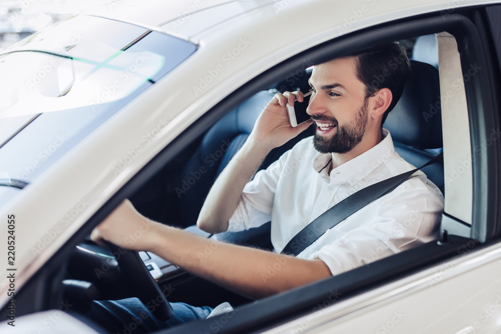 man sitting in the car and talking on smartphone