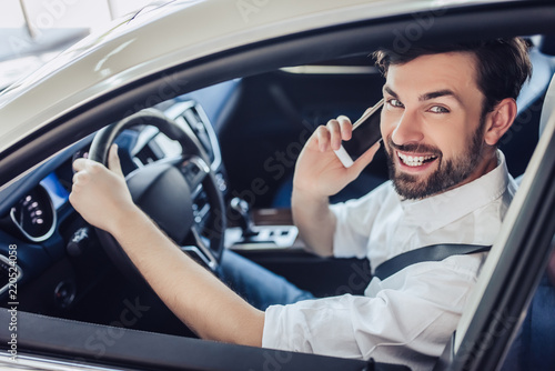 man sitting in the car and talking on smartphone