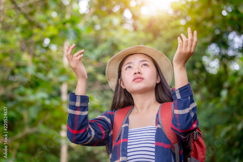 Young traveler woman in hipster style with backpack and hat standing looking the sky