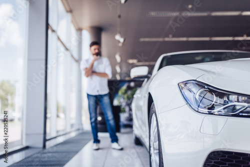 pensive man in dealership salon