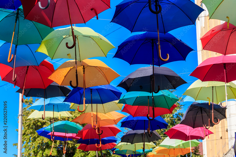 Multicolored umbrellas on the city street. The city street is decorated with many colorful open umbrellas