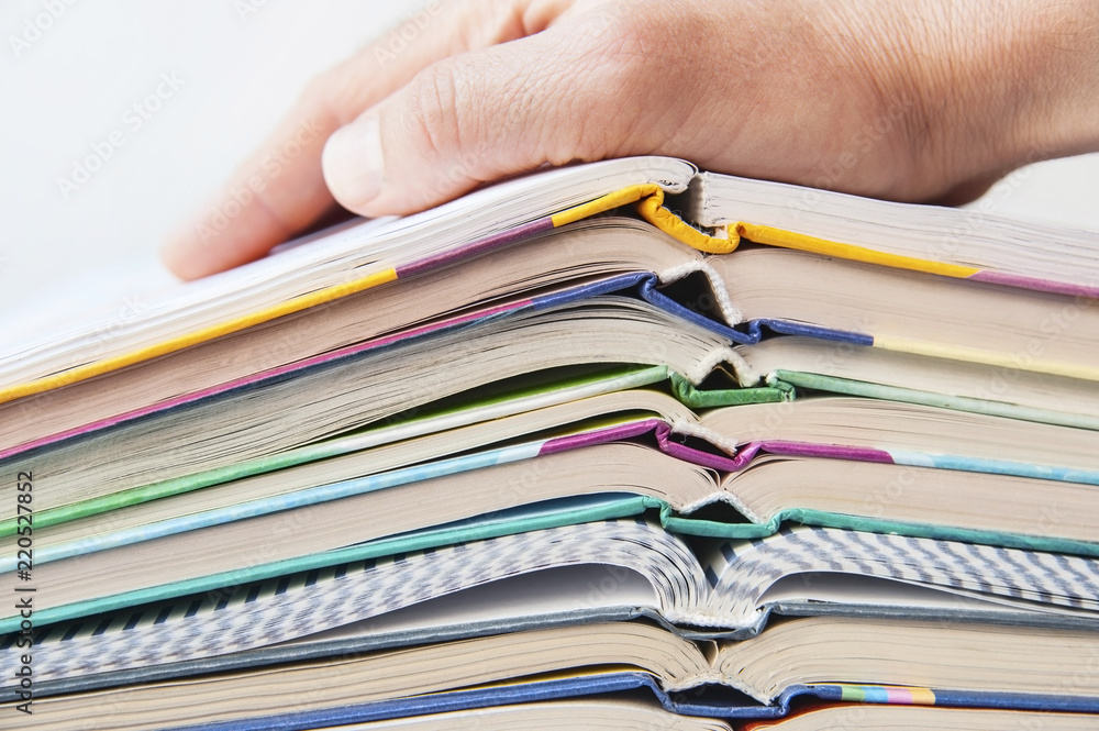 Discovered school books lie on one another, the hand of a man lies on books. Learning concept Discovered school books lie on one another, the hand of a man lies on books. Learning concept