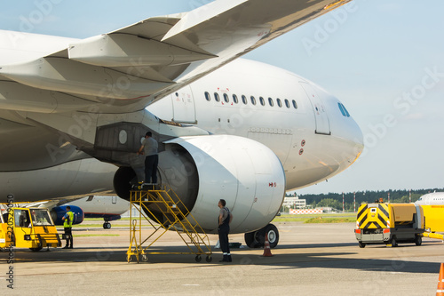 Ground maintenance of large modern widebody white airplane at international airport