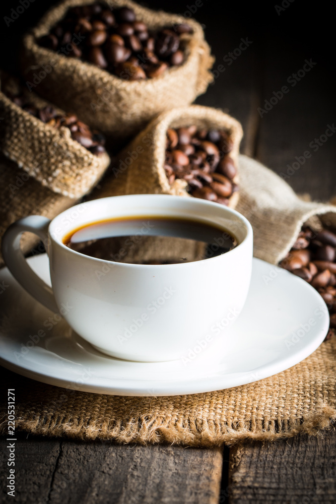 Coffee cup and beans on a rustic background. Coffee Espresso and a piece of cake with a curl. Cup of Coffee and coffee beans on table. Coffee cup and beans on a rustic background. Coffee Espresso and a piece of cake with a curl. Cup of Coffee and coffee beans on table.