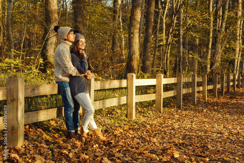 Fototapeta premium Young couple in the park at sunny autumn day