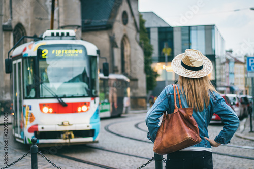 Woman looking at passing tram in ancient city Olomouc, Czech Republic