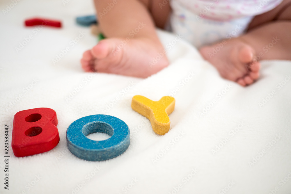 boy text wooden word on blanket with blurred kid foot and copy space background boy text wooden word on blanket with blurred kid foot and copy space background