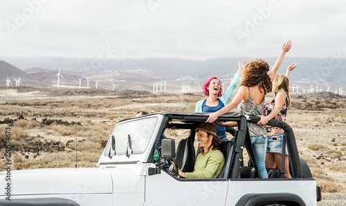 Happy tourists friends doing excursion on desert in convertible 4x4 car © DisobeyArt