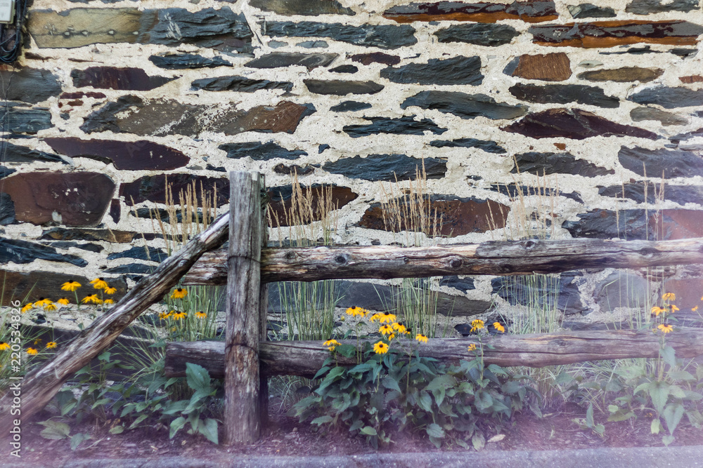 A rustic background. A wooden fence and an old stone wall. 