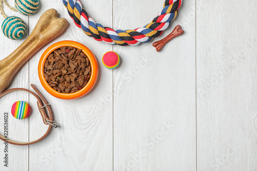 Fototapeta Naklejka Na Ścianę i Meble -  Bowl with food for dog or cat and accessories on wooden background. Pet care