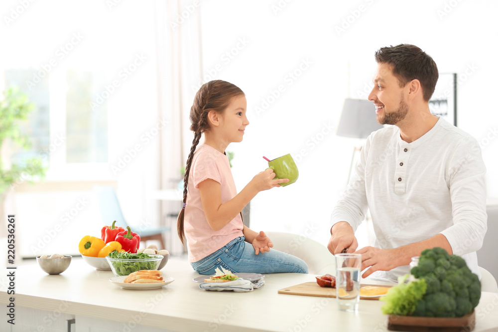 Father and daughter preparing breakfast together in kitchen Father and daughter preparing breakfast together in kitchen