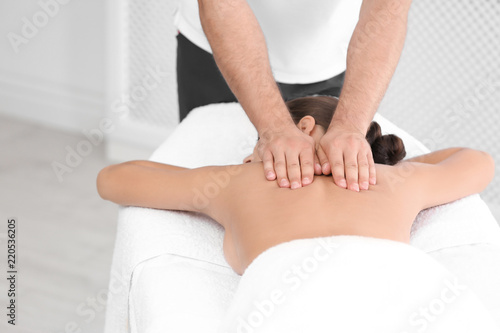 Relaxed woman receiving back massage in wellness center