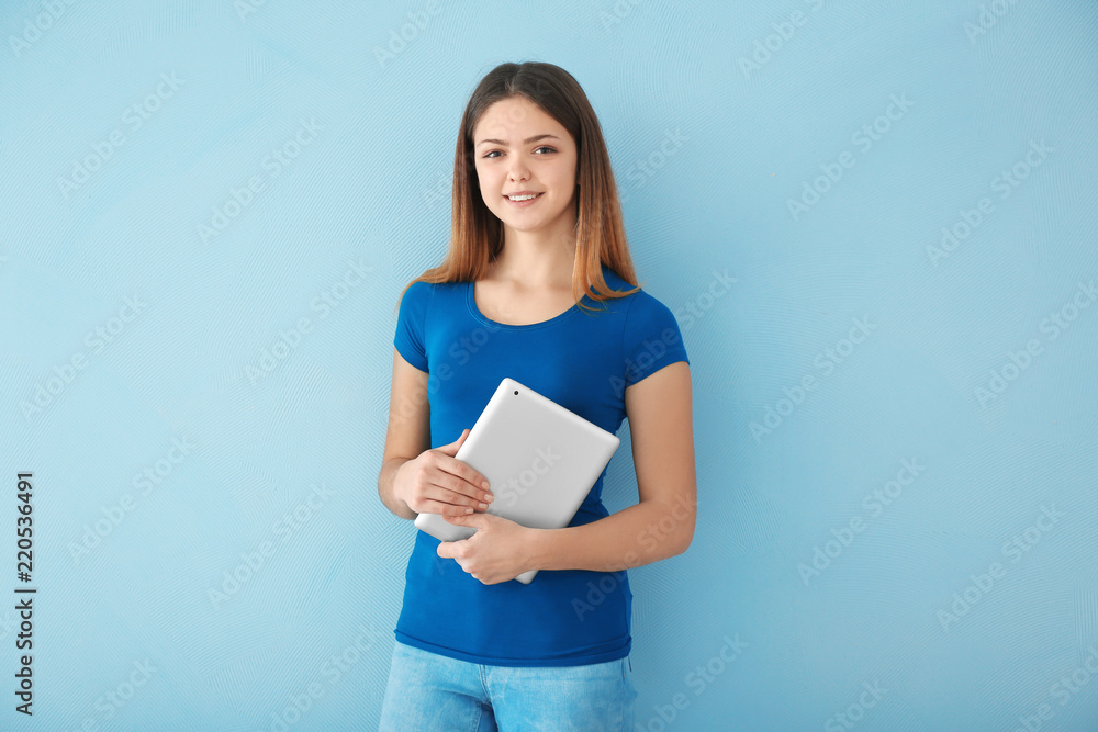 Teenage girl with tablet computer on color background Teenage girl with tablet computer on color background