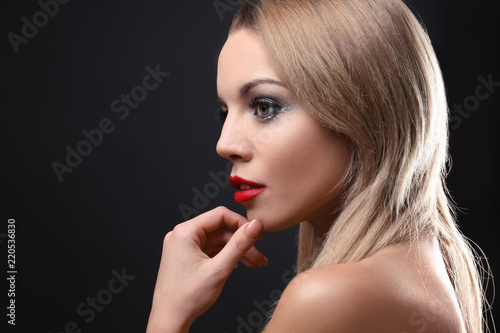 Portrait of beautiful young woman with eyelash extensions on dark background
