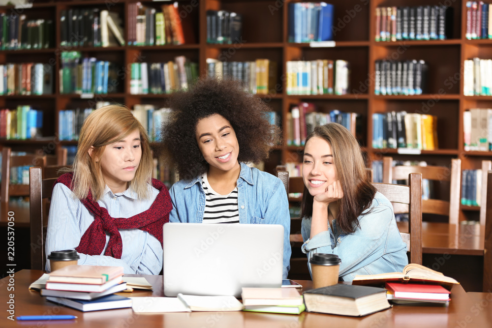 Group of students studying at table in library Group of students studying at table in library