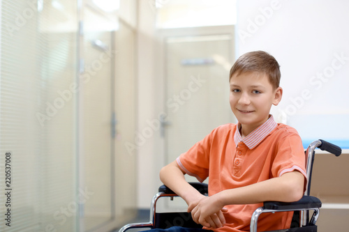Little boy sitting in wheelchair indoors