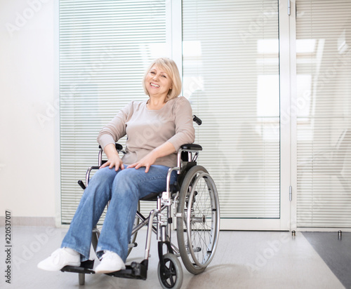 Mature woman sitting in wheelchair indoors
