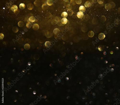 glitter vintage lights background. black and gold. de-focused.