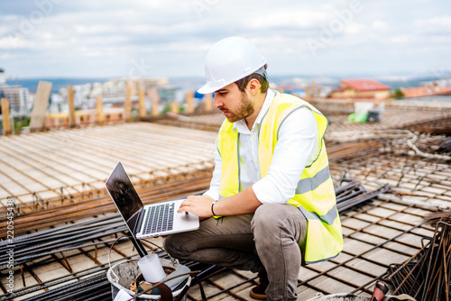 Construction engineer  architect planning with laptop  using technology at construction site