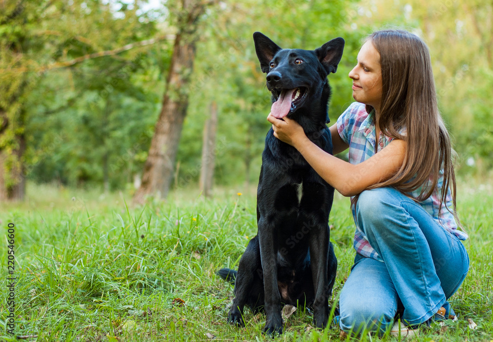 Portrait of young teenage girl with a shepherd dog in the park outdoor Portrait of young teenage girl with a shepherd dog in the park outdoor