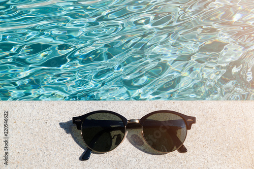 Sunglasses the side of swimming pool, summer travel concept