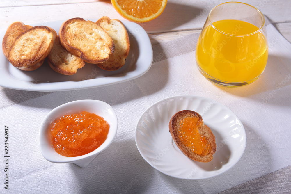 Morning Breakfast set with orange jam on bread toast and juice in glass. Morning Breakfast set with orange jam on bread toast and juice in glass.