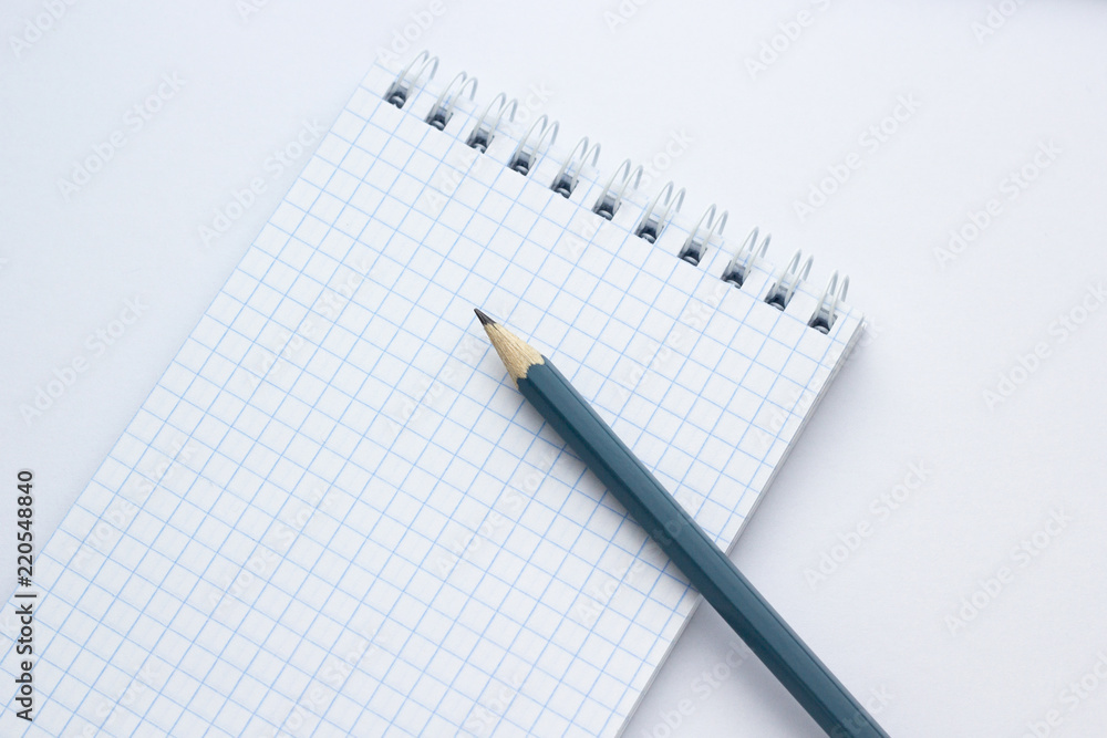 Pencil and notebook on white background, close-up Pencil and notebook on white background, close-up