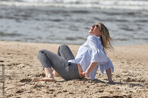 young blode girl is playing with a ball in summer spring at the beach photo