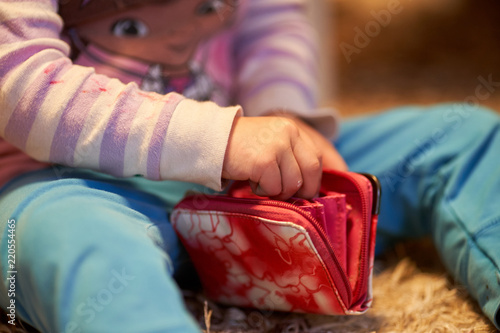 3 yearls old caucasian girl child is playing with money and wallet