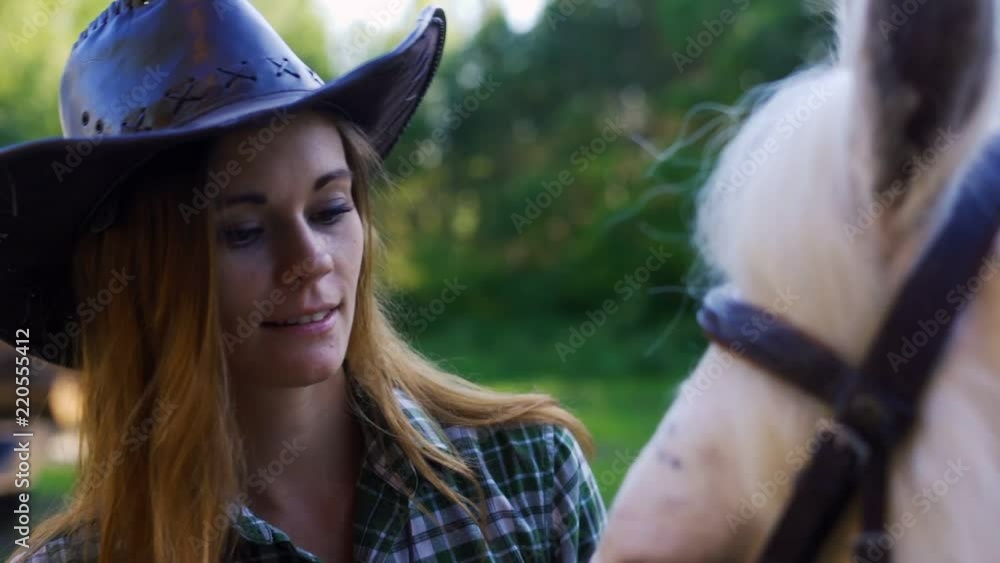 Portrait of a girl in a cowboy hat stroking a horse. Portrait of a girl in a cowboy hat stroking a horse.