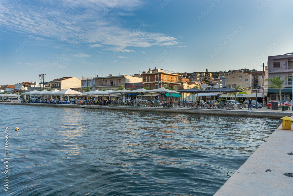 Panoramic sunset view of Argostoli city in Kefalonia Greece. View of the port and the traditional houses. People enjoying their coffee or food along the embankment