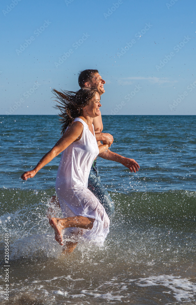 running happy couple on the beach running happy couple on the beach