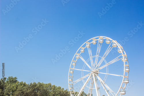 carnival outdoor park space and white ferris wheel cycle shape object on blue sky background and empty space for copy or text