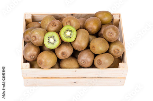 Wooden box filled with many ripe and fresh kiwi fruits and two half fruits isolated on white background