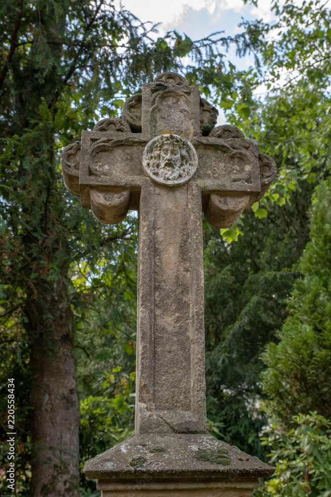 Schönes altes Steinkreuz mit dem Antlitz von Jesus Schönes altes Steinkreuz mit dem Antlitz von Jesus